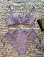 A light purple lace lingerie set from Immogene Olivia Gender Euphoric Lingerie consisting of a structured lace bralette and matching high-waisted lace and modal briefs, laid flat. (non tucking panties,  mtf, transgender lingerie, gender inclusive, trans women, trans underwear, gender affirming lingerie)