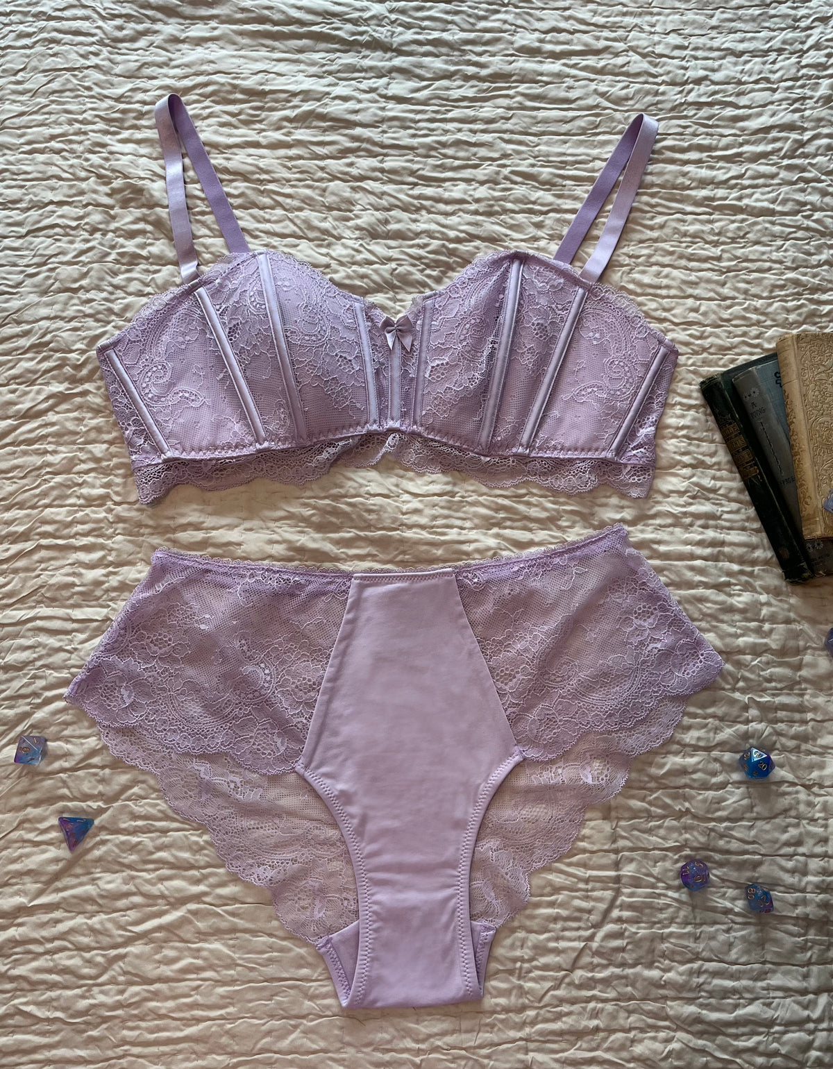 A light purple lace lingerie set from Immogene Olivia Gender Euphoric Lingerie consisting of a structured lace bralette and matching high-waisted lace and modal briefs, laid flat. (non tucking panties,  mtf, transgender lingerie, gender inclusive, trans women, trans underwear, gender affirming lingerie)
